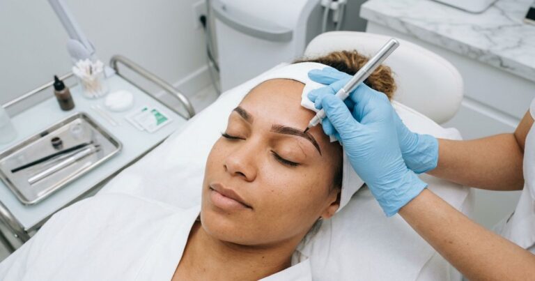 microblading sourcil : mains gantees realisant une seance de micropigmentation